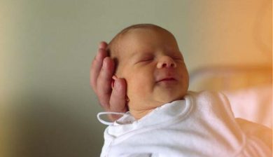 Kopf eines neugebornen Babys auf der Hand