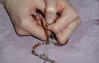 betende Hände mit Rosenkranz