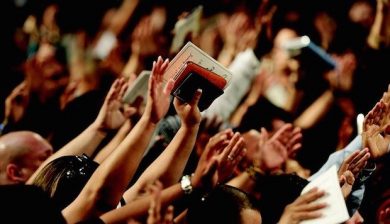 viele Menschen im Gebet mit erhobenen Händen