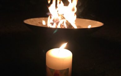 Feuer in einer Schale und brennende Kerze